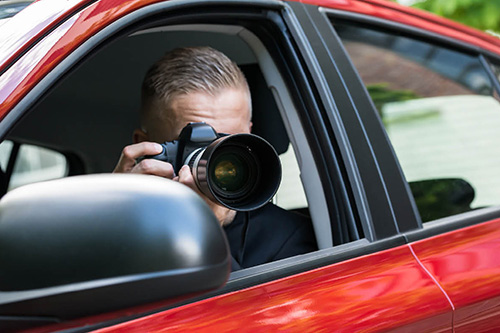 An investigator takes photos from the front seat of a car