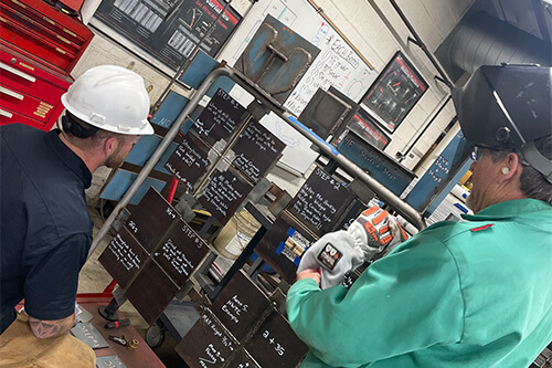 A worker and an instructor review the steps of a process