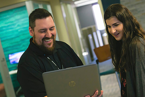 An admissions advisor works with a student in the Welcome center