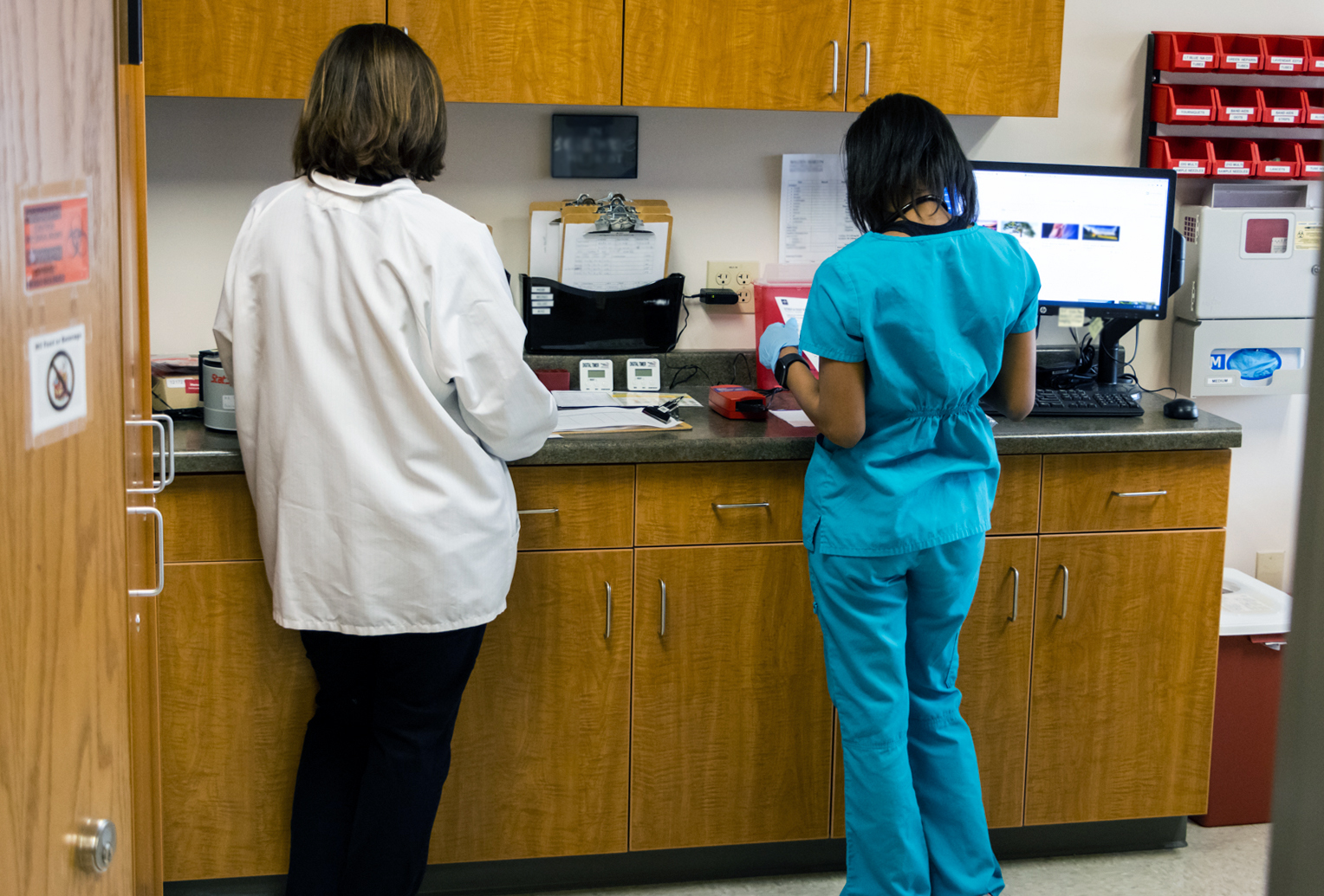 Doctor and lab tech stand assessing results