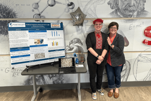 Eli and Dr. Raney smiling and standing next to each other next to a presentation board.