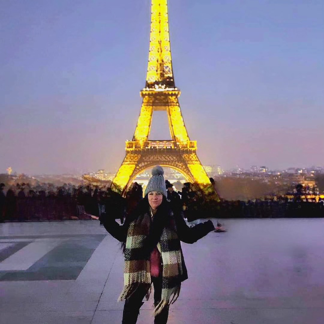 Melinda Gregurich standing in front of the Eiffel Tower.