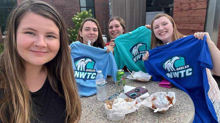 Students hold up NWTC Eagles t-shirts