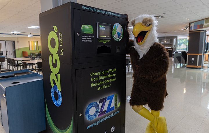 Eagle mascot leans against Ozzi machine