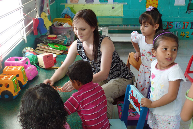 A student works with children on a study abroad trip in Beize