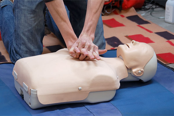 Hands positioned over the heart of a CPR dummy
